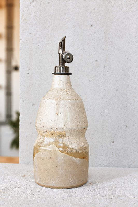 Ceramic oil bottle in light sand